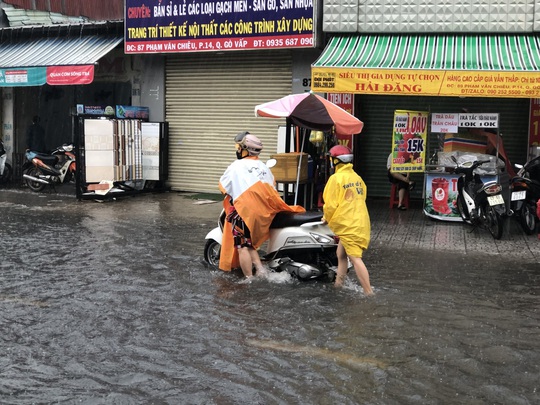 CLIP: Người dân nhiều nơi ở TP HCM, Bình Dương ngụp lặn sau cơn mưa lớn - Ảnh 2.