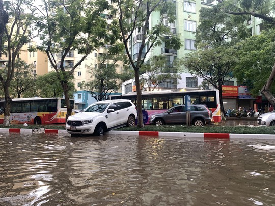 CLIP: Nhiều tuyến phố ở Hà Nội ngập sâu, xe cộ bì bõm sau trận mưa lớn - Ảnh 8.