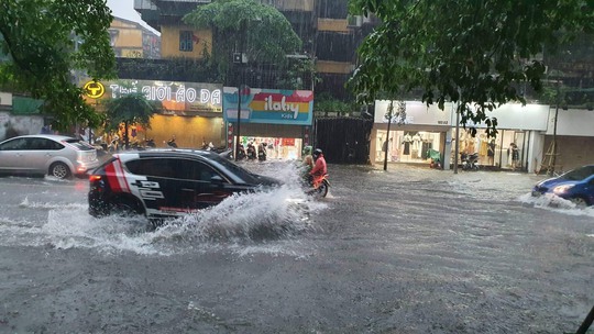 CLIP: Nhiều tuyến phố ở Hà Nội ngập sâu, xe cộ bì bõm sau trận mưa lớn - Ảnh 7.