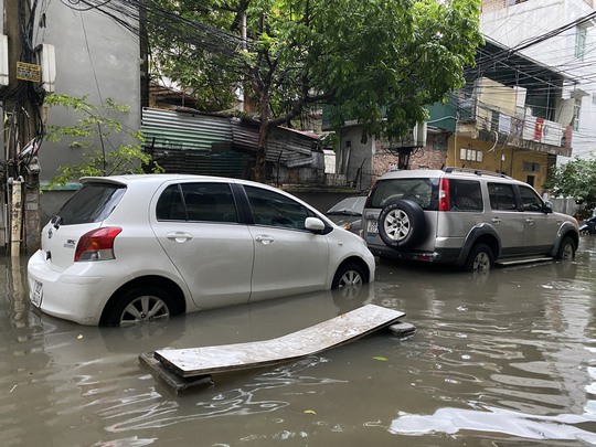 CLIP: Nhiều tuyến phố ở Hà Nội ngập sâu, xe cộ bì bõm sau trận mưa lớn - Ảnh 2.