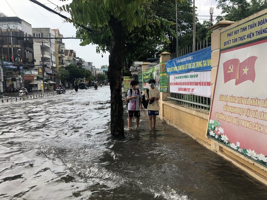 CLIP: Đường ngập, người dân bì bõm sau cơn mưa lớn ở TP HCM - Ảnh 2.