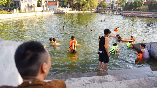 Nắng nóng, người dân Hà Nội ùn ùn kéo tới các bãi tắm tự phát - Ảnh 7.