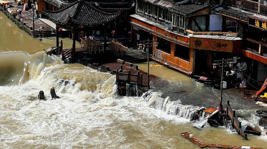 Mưa xối xả ở Trung Quốc, 25 người chết, Phượng Hoàng cổ trấn chìm trong lũ - Ảnh 1.