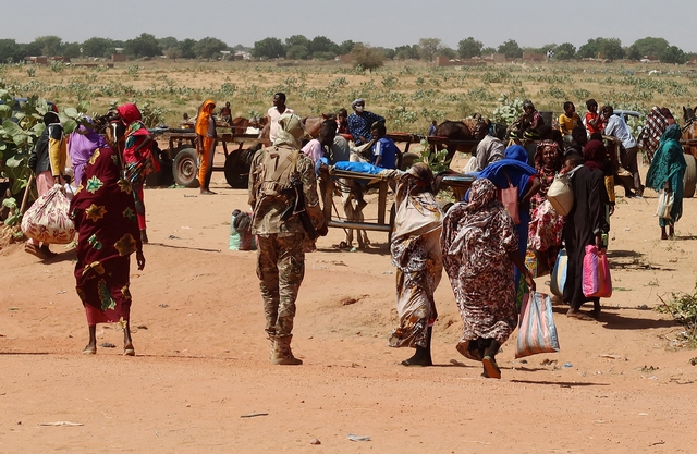 Người dân bang Tây Darfur - Sudan rời bỏ nhà cửa hôm 7-11 để băng qua biên giới đến thị trấn Adre của Chad tị nạn Ảnh: REUTERS