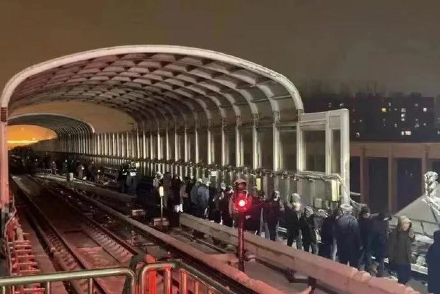 Hành khách đi bộ ra khỏi hiện trường tai nạn tàu điện ngầm Bắc Kinh