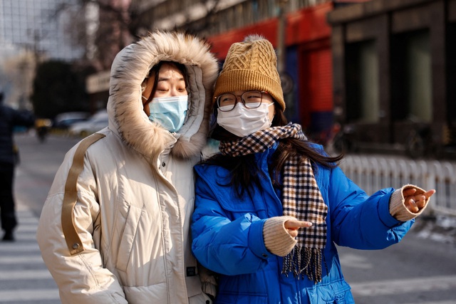Người dân đi giữa thời tiết lạnh giá của thủ đô Bắc Kinh - Trung Quốc hôm 18-12 Ảnh: REUTERS