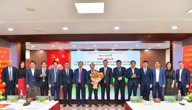 Ông Phạm Quang Dũng - Chủ tịch HĐQT Vietcombank (bên phải) tặng hoa chúc mừng ông Đỗ Việt Hùng