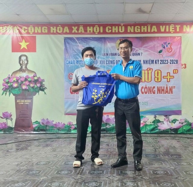 Ông Trần Cộng - Phó Chủ tịch LĐLĐ quận 7, TP HCM - trao quà cho công nhân khó khăn