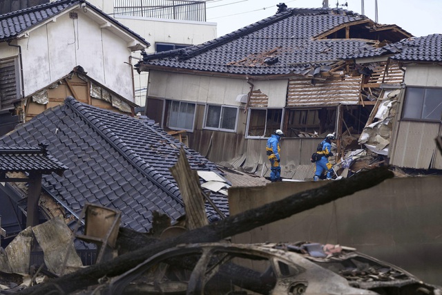 Cảnh sát tìm kiếm người mất tích tại một ngôi nhà bị sập do động đất ở TP Wajima, tỉnh Ishikawa ngày 2-1 Ảnh: KYODO