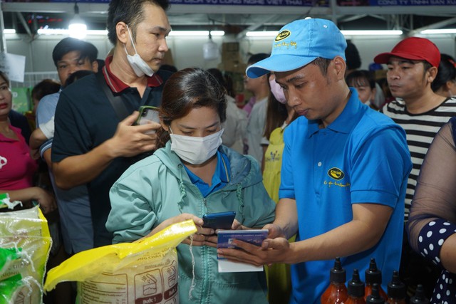 Công nhân quét mã thanh toán tại “Ngày hội CN - Phiên chợ nghĩa tình” do LĐLĐ TP HCM tổ chức tại quận Bình Tân Ảnh: CAO HƯỜNG