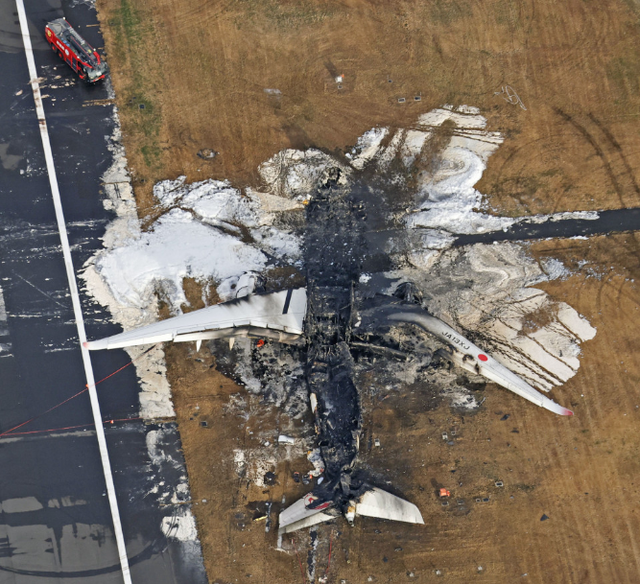 Xác chiếc máy bay chở khách cháy rụi trong ảnh chụp ngày 3-1. Ảnh: Kyodo