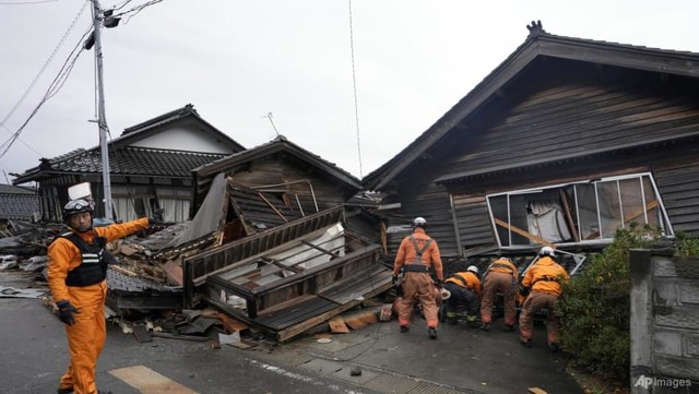 Lực lượng cứu hộ tìm kiếm trong ngôi nhà bị sập do trận động đất mạnh ở Suzu, tỉnh Ishikawa - Nhật Bản hôm 3-1. Ảnh: AP