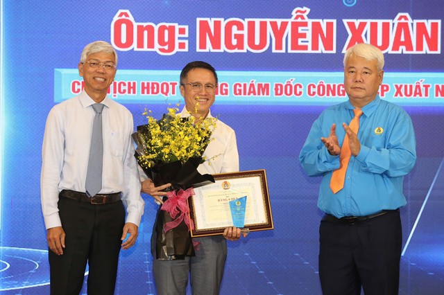 Ông Võ Văn Hoan, Phó Chủ tịch UBND TP HCM (bìa trái) và ông Võ Khắc Thái, Chủ tịch LĐLĐ TP HCM, vinh danh ông Nguyễn Xuân Dũng. Ảnh: HOÀNG TRIỀU