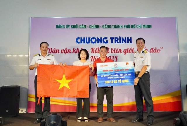 Ông Bùi Thanh Liêm (thứ 2 từ phải qua), Phó Tổng biên tập Báo Người Lao Động, trao bảng tượng trưng 500 lá cờ Tổ quốc cho Lữ đoàn 167 - Vùng 2 Hải quân