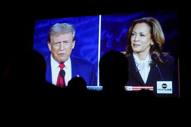 Donald Trump and Kamala Harris on screen during a debate watch party in Fayetteville, North Carolina, on Sept. 10.Photographer: Allison Joyce/Bloomberg