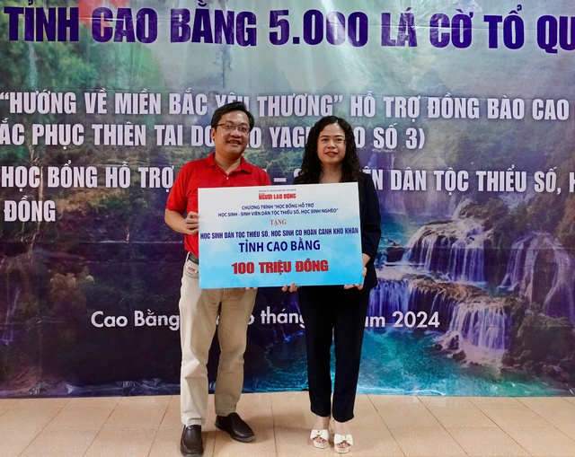 Ông Lê Cao Cường, Phó Tổng Biên tập Báo Người Lao Động, trao bảng tượng trưng 100 triệu đồng học bổng cho bà Đàm Trung Thu, Phó Giám đốc Sở Giáo dục và Đào tạo tỉnh Cao Bằng