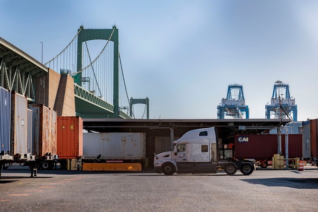 A truck drives past shipping containers at the Port of Philadelphia in Pennsylvania on Nov. 6. Photographer: Hannah Beier/Bloomberg