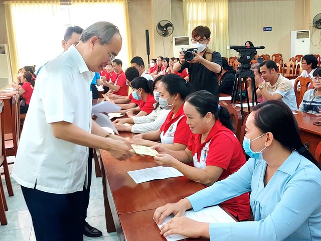 Ông Nguyễn Thiện Nhân, Nguyên Ủy viên Bộ Chính trị, Nguyên Bí thư Thành ủy TP HCM, tặng quà cho công nhân Ảnh: CAO HƯỜNG