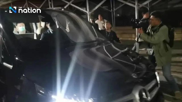 Phóng viên vây quanh chiếc xe gia đình của ông Thaksin sáng sứm 18-2 - Ảnh: THAI NEW PIX