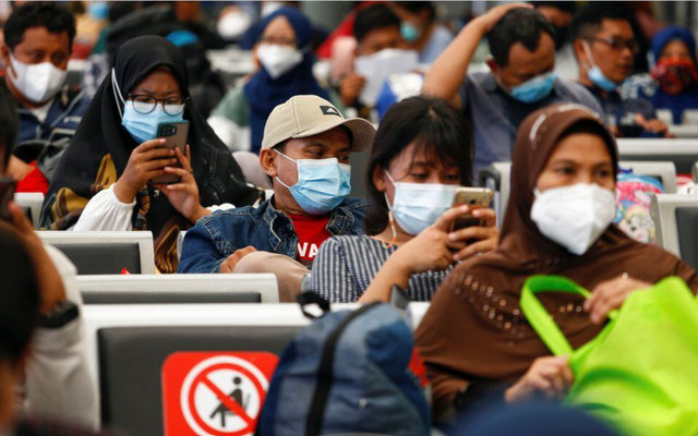 Hành khách sử dụng điện thoại ở một ga xe lửa ở thủ đô Jakarta - Indonesia  Ảnh: REUTERS