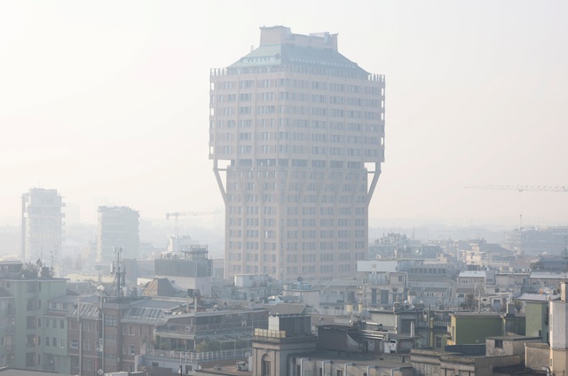 Các tòa nhà cao tầng bị bao phủ trong bụi mù ở TP Milan - Ý hôm 20-2  Ảnh: REUTERS