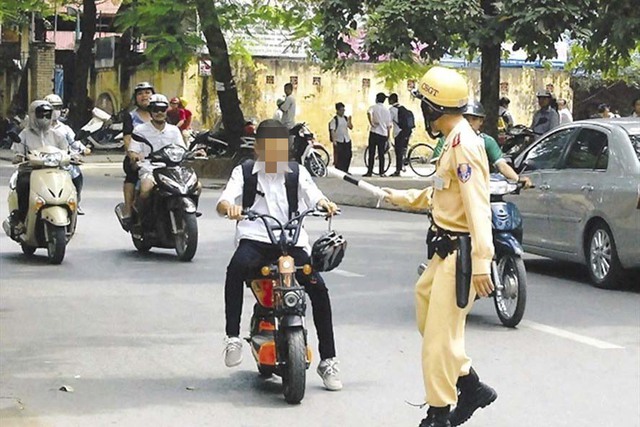 Một học sinh trên địa bàn TP Hà Nội không đội mũ bảo hiểm khi điều khiển xe máy điện  Ảnh: Tuấn Lương