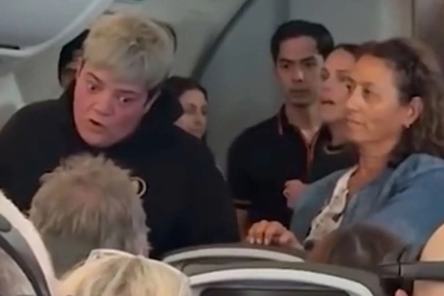 Người phụ nữ có mái tóc ngắn màu vàng, hét vào mặt hành khách nam đang ngồi. Ảnh: TikTok