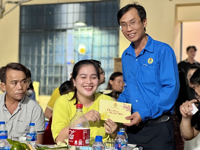 Ông Trần Cộng - Phó Chủ tịch LĐLĐ quận 7, TP HCM - trao quà cho đoàn viên - lao động không có điều kiện về quê đón Tết Ảnh: HUỲNH NHƯ