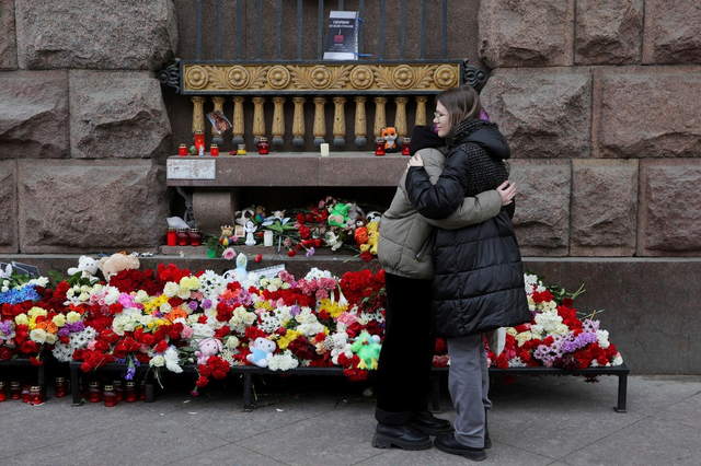Hai phụ nữ ôm nhau ở khu vực tưởng niệm các nạn nhân trong vụ tấn công Crocus City Hall. Ảnh: Reuters