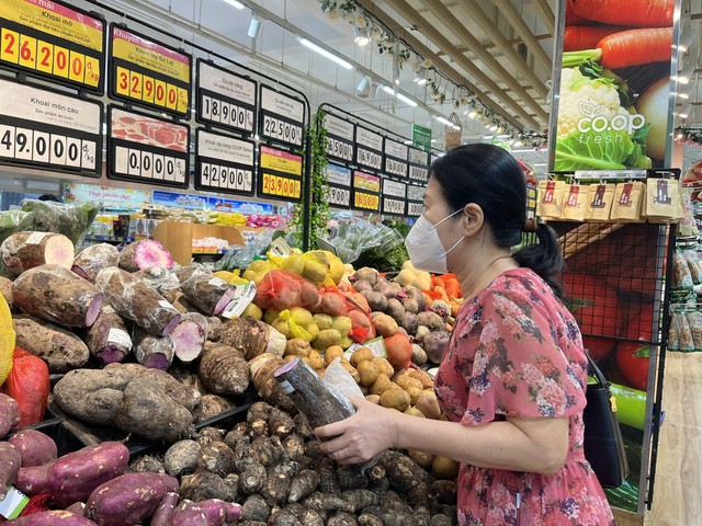 Người tiêu dùng chọn mua rau củ và thực phẩm thiết yếu tại một siêu thị chiều 17-4