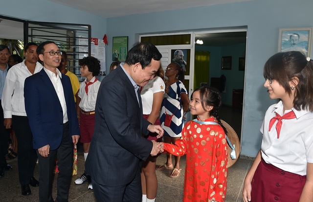 Phó Thủ tướng Trần Lưu Quang thăm hỏi một học sinh Việt Nam theo học tại Trường Tiểu học Võ Thị Thắng Ảnh: VGP