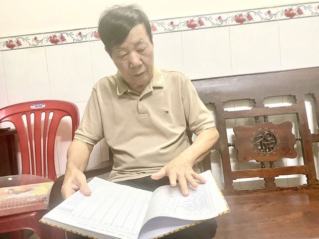 Ông Lê Xuân Quyền vừa coi sổ sách của Chi bộ Khu phố 2 cũ vừa chia sẻ niềm vui trong nhiệm vụ mới vừa được tin tưởng giao phó
