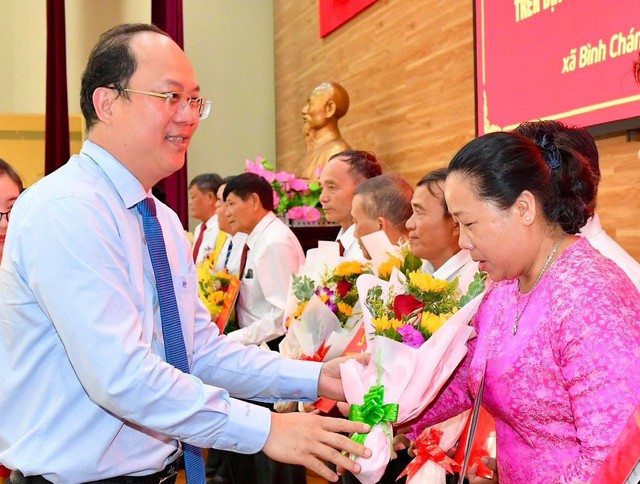 Phó Bí thư Thường trực Thành ủy TP HCM Nguyễn Hồ Hải tặng hoa chúc mừng ban điều hành ấp mới tại xã Bình Chánh, huyện Bình Chánh  Ảnh: VIỆT DŨNG