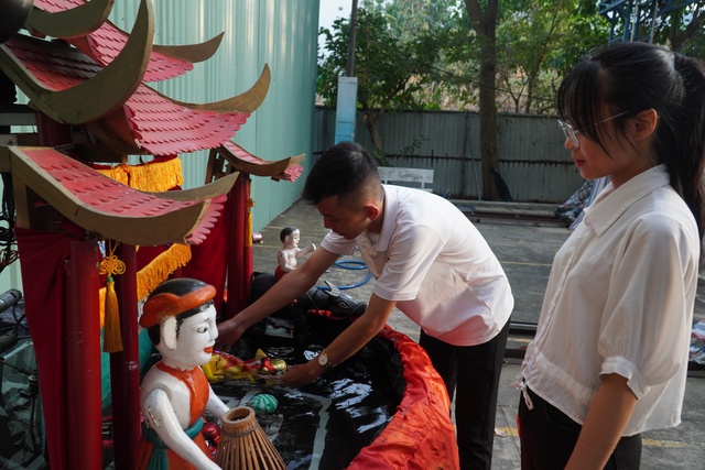Huỳnh Minh Thuận bên mô hình robot múa rối nước