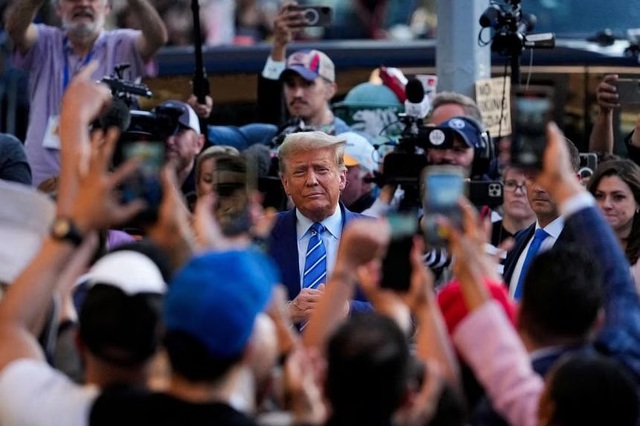 Cựu Tổng thống Mỹ Donald Trump dừng chân vận động tranh cử tại cửa hàng tiện lợi Sanaa, ở khu Harlem của TP New York, ngày 16-4. Ảnh: Reuters