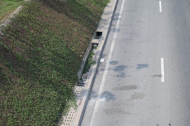 Hàng chục tấm đan cống thoát nước trên xa lộ Hà Nội lại bị kẻ gian phá hoại- Ảnh 1.