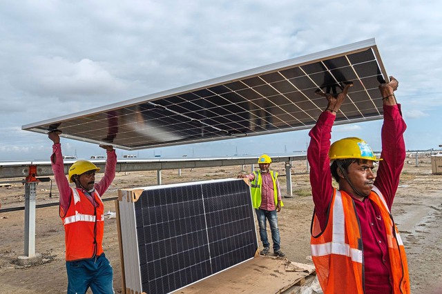 Công nhân lắp đặt tấm pin năng lượng mặt trời tại nhà máy Khavda Renewable Energy Park ở bang Gujarat - Ấn Độ Ảnh: AP