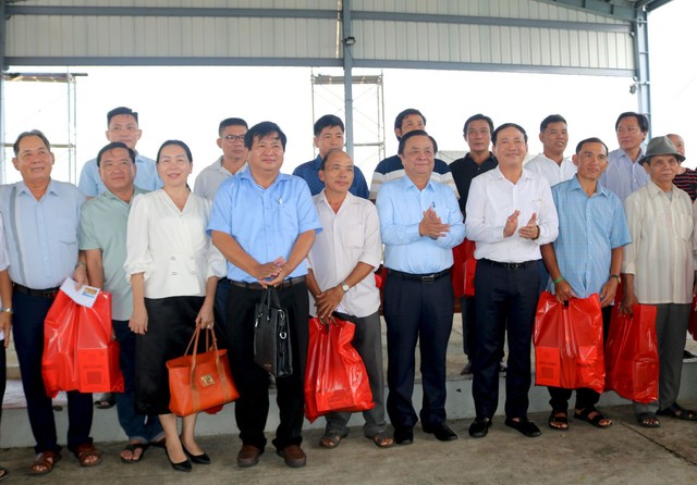 Bộ trưởng Lê Minh Hoan và Chủ tịch UBND tỉnh Bình Định Phạm Anh Tuấn (hàng đầu, thứ 4 và thứ 5 từ trái sang) tặng quà cho các ngư dân nhân chuyến thị sát tại cảng cá Đề Gi