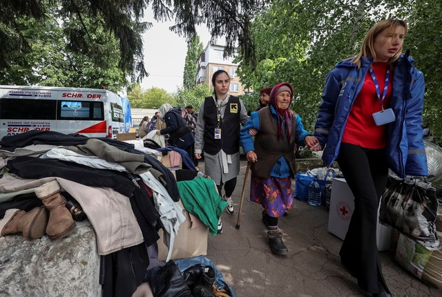 Người dân từ Vovchansk chạy trốn pháo kích của Nga ngày 13-5. Ảnh: Reuters