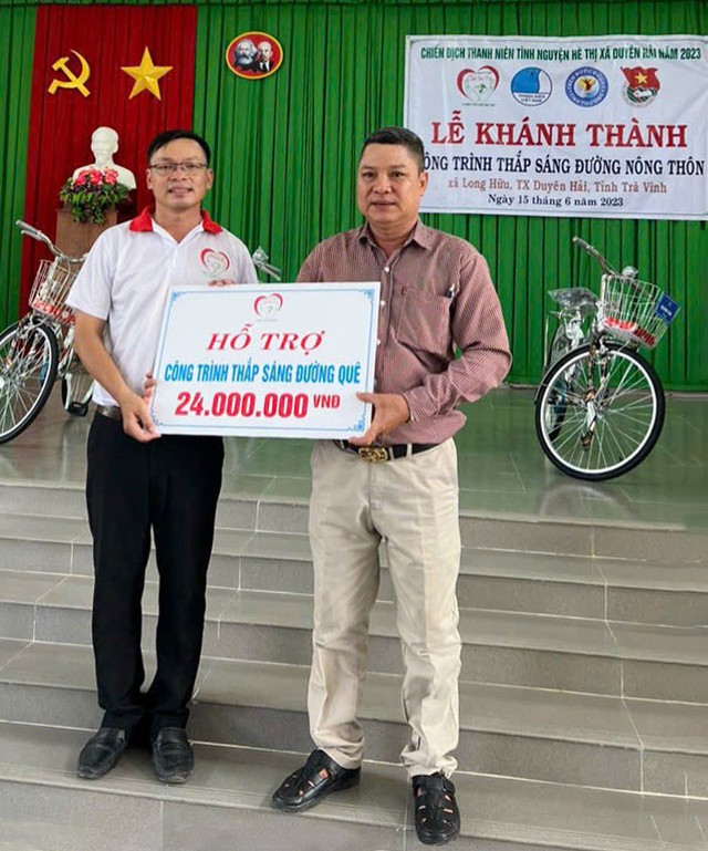 Anh Nguyễn Thanh Tuấn (trái) trao kinh phí hỗ trợ công trình Thắp sáng đường quê tại xã Hữu Long, thị xã Duyên Hải, tỉnh Trà Vinh.  (Ảnh do nhân vật cung cấp)