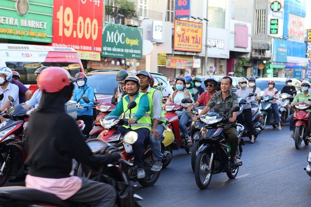 Một người đi xe máy có mũ bảo hiểm nhưng không đội. Ảnh chụp trên đường Phan Đình Phùng, quận Phú Nhuận, TP HCM Ảnh: MINH DIỄM