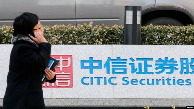 Một phụ nữ đi ngang qua biển hiệu của Tập đoàn Citic có trụ sở chính tại Bắc Kinh – Trung Quốc. Ảnh: Reuters
