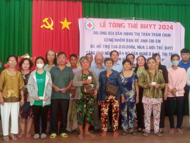 Ông Bùi Văn Hanh (thứ 4 từ trái qua) trong một lần tặng thẻ BHYT cho người nghèo ở tỉnh Đồng Tháp