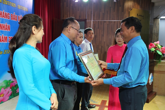 Ông Trần Đăng Công Nghĩa, Chủ tịch Công đoàn ngành y tế TP HCM, trao bằng khen của Tổng LĐLĐ Việt Nam cho các cá nhân có nhiều đóng góp trong Tháng Công nhân