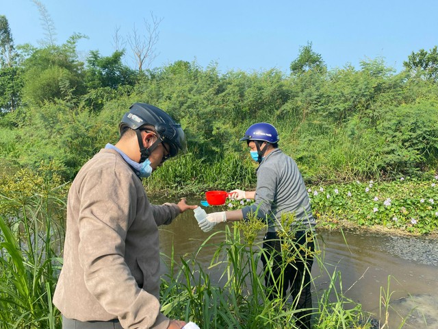 Nhân viên môi trường lấy mẫu nước thải bị ô nhiễm nặng tại một nhánh kênh mương gần cụm công nghiệp làng nghề Tịnh Ấn Tây