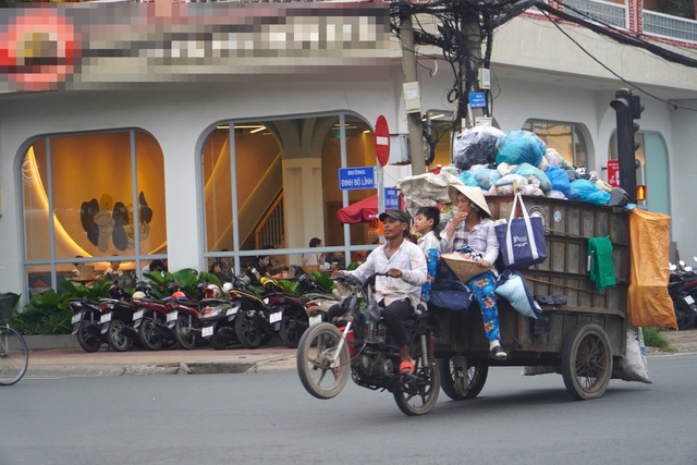 4 thành viên trong gia đình ngồi vắt vẻo trên xe chở rác đầy ắp lưu thông trên giao lộ Đinh Bộ Lĩnh - Chu Văn An, quận Bình Thạnh, TP HCMẢnh: Quốc Anh