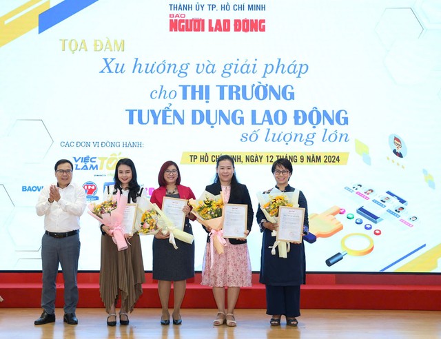 Nhà báo Dương Quang, Phó Tổng Biên tập Báo Người Lao Động, trao hoa cảm ơn các đơn vị đồng hành. Ảnh: HOÀNG TRIỀU