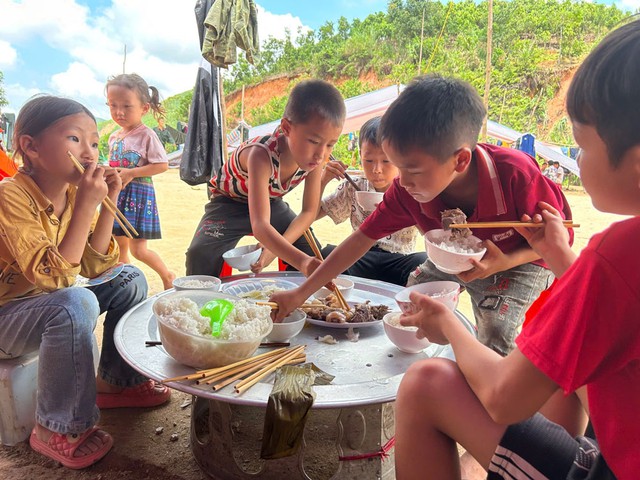 Nhà bị sạt lở, đất vùi lấp, trẻ em thôn Nậm Tông ăn uống chung trong lán ở tạm. Ảnh: MINH CHIẾN