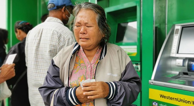 Bà Noi Yaemprakon, 64 tuổi, rút 10.000 baht do chính phủ chuyển khoản từ máy ATM ở tỉnh Buriram - Thái Lan. Bà khóc nói chưa được chạm vào số tiền 10.000 baht (khoảng 7,6 triệu đồng) hơn 10 năm nay Ảnh: KHAOSOD