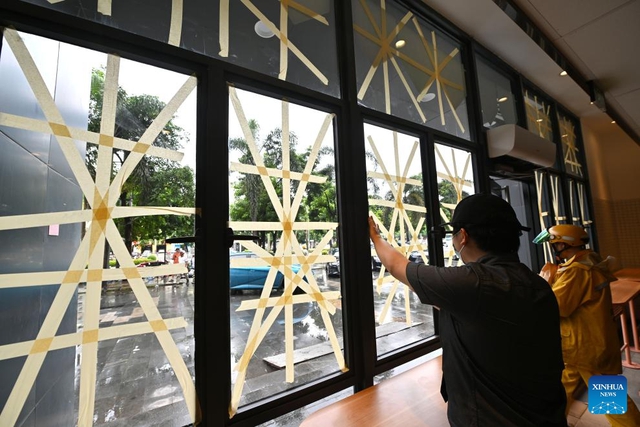 A staff member reinforces a glass window in Haikou, south China's Hainan Province, Sept. 5, 2024. The State Flood Control and Drought Relief Headquarters raised its emergency response for flood and typhoon prevention from level III to level II in Guangdong and Hainan provinces at 3 p.m. Thursday, as typhoon Yagi approaches.  Yagi is expected to make landfall on Friday afternoon or evening somewhere between the city of Qionghai in Hainan and Maoming City in Guangdong. (Xinhua/Guo Cheng)